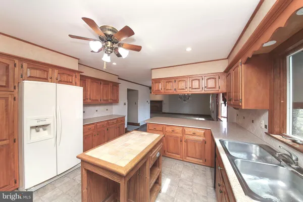 a kitchen with stainless steel appliances granite countertop a sink a stove top oven a chimney and a refrigerator