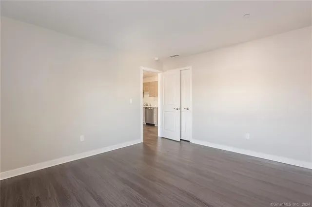 a view of an empty room with wooden floor