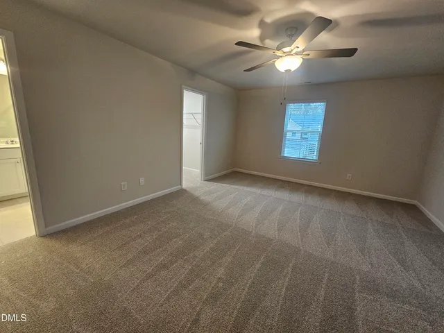 a view of an empty room with a chandelier fan