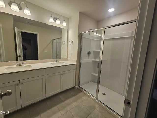 a bathroom with a double vanity sink and a mirror