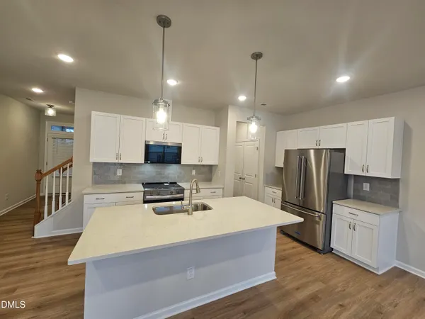 a kitchen with kitchen island a counter top space stainless steel appliances and cabinets