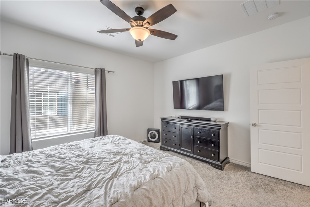 7232 North Decatur Boulevard, Unit 4 North Las Vegas, NV 89084 - Photo 20 of 36 Bedroom with light carpet, ceiling fan, visible vents, and baseboards