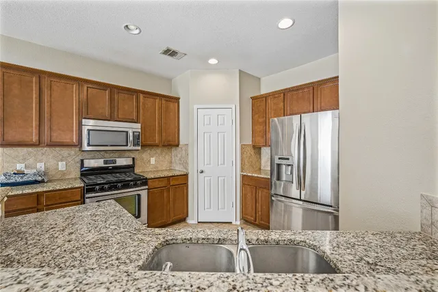 a kitchen with a refrigerator sink and stove