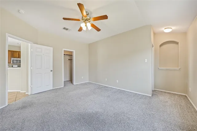 an empty room with closet and a chandelier fan