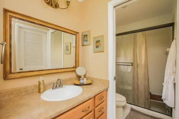 a bathroom with a granite countertop sink toilet and shower