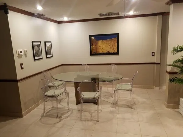 a living room with couch chairs and a refrigerator