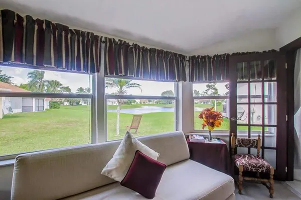 a living room with furniture and a floor to ceiling window
