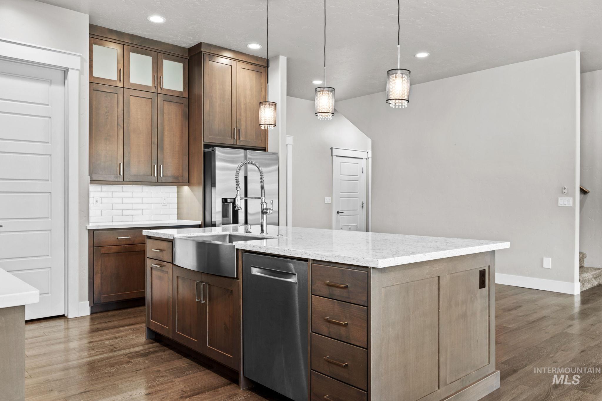2934 East Murchison Street Meridian, ID 83642 - Photo 12 of 44 Kitchen featuring a central island with white countertop, stainless steel farmhouse sink, and integrated dishwasher