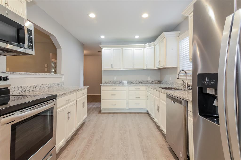 4821 Ashbrook Road Dallas, TX 75227 - Photo 6 of 21 a kitchen with granite countertop white cabinets and stainless steel appliances