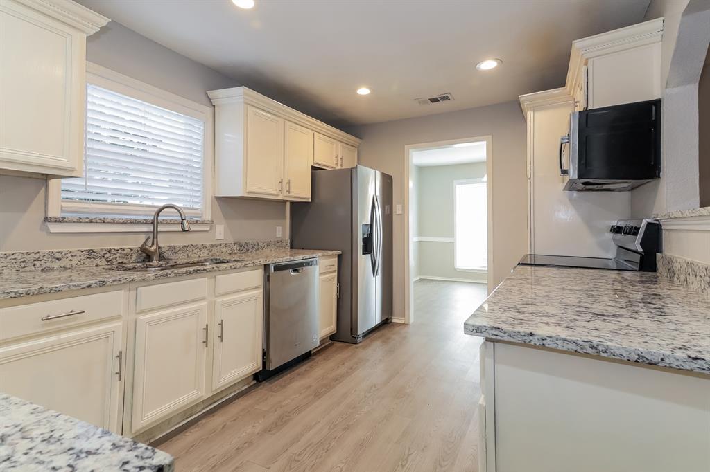 4821 Ashbrook Road Dallas, TX 75227 - Photo 7 of 21 a kitchen with granite countertop a sink stove and refrigerator