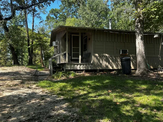 a view of backyard with wooden fence and a large tree