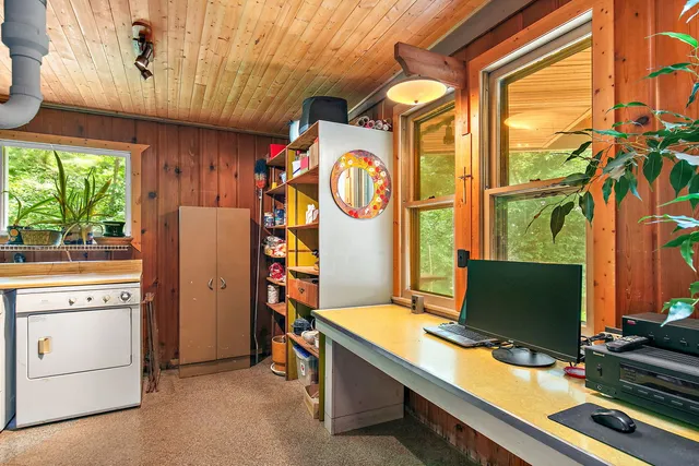 a view of a workspace with furniture and a window