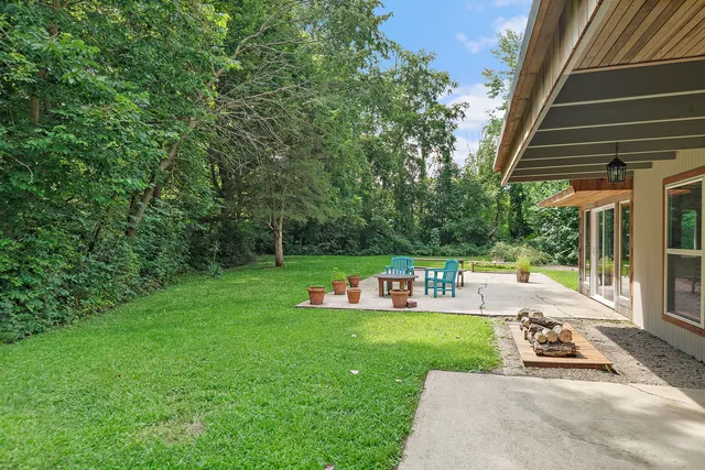 a view of backyard with swimming pool and seating space
