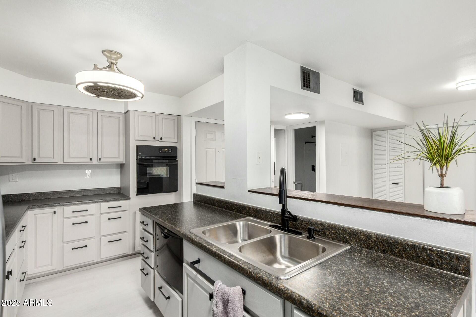 a kitchen with granite countertop a sink and a stove