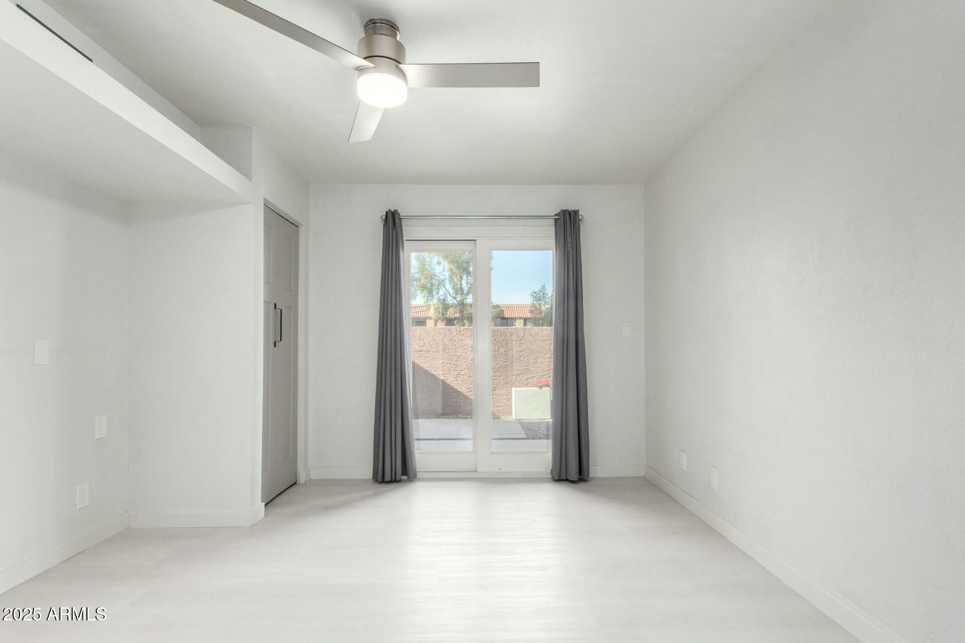 540 North May, Unit 1075 Mesa, AZ 85201 - Photo 19 of 23 an empty room with chandelier fan and windows