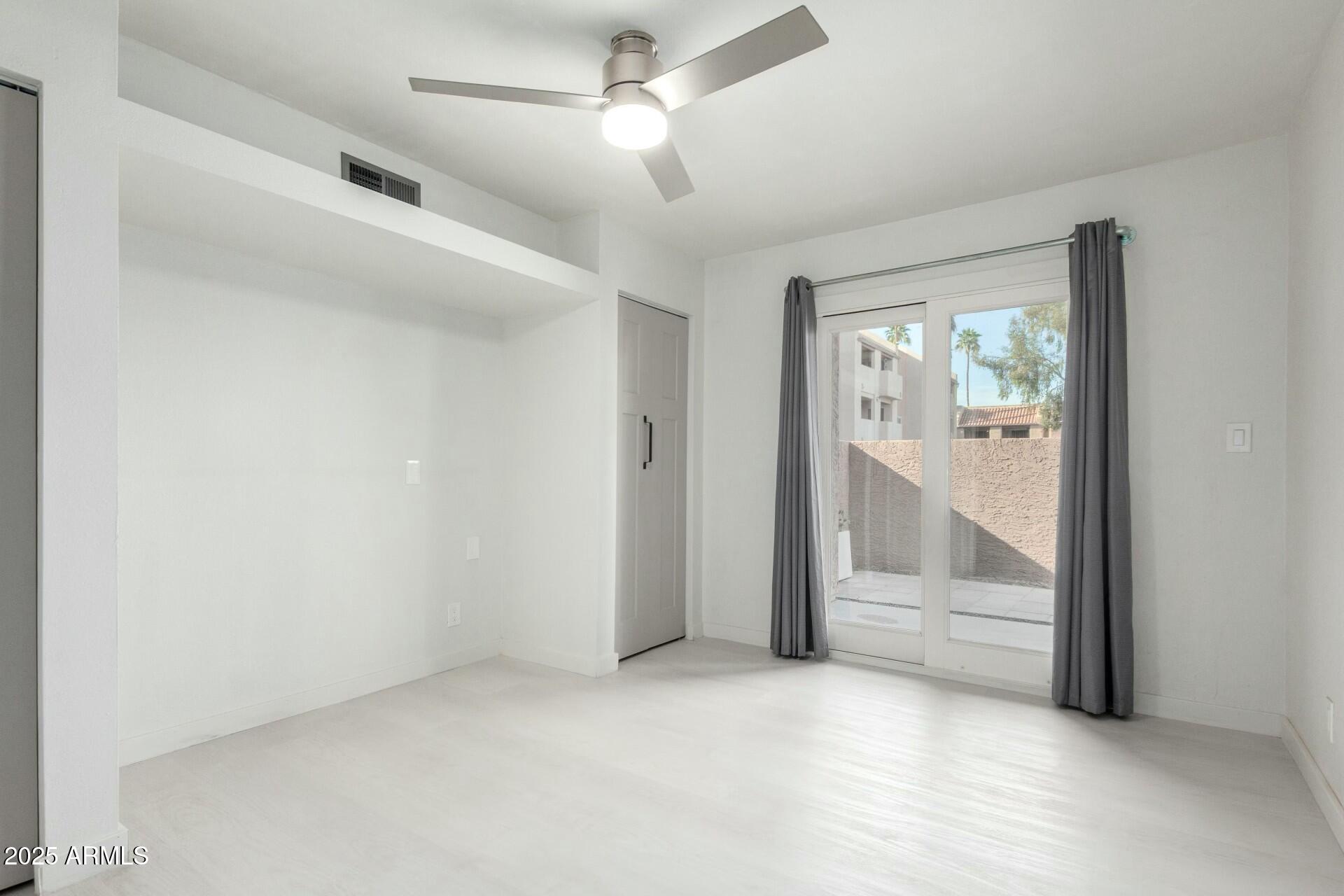 540 North May, Unit 1075 Mesa, AZ 85201 - Photo 20 of 23 an empty room with a ceiling fan and windows