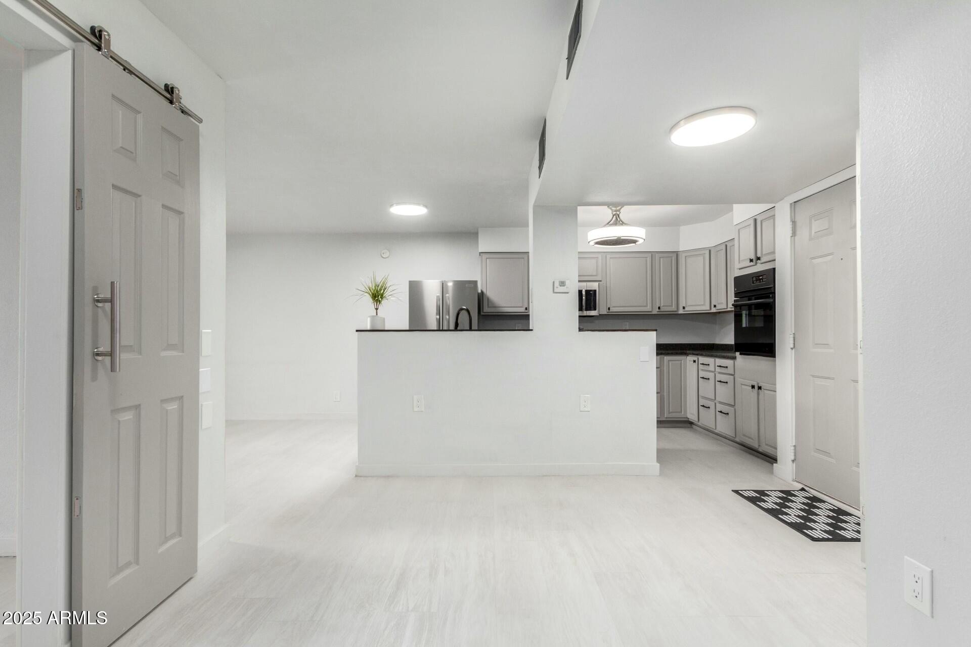 540 North May, Unit 1075 Mesa, AZ 85201 - Photo 7 of 23 a large white kitchen with white cabinets and stainless steel appliances