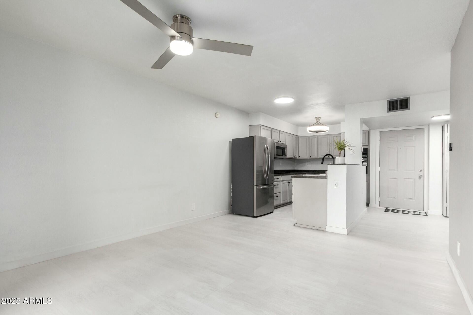 540 North May, Unit 1075 Mesa, AZ 85201 - Photo 10 of 23 a view of kitchen with refrigerator and white cabinets