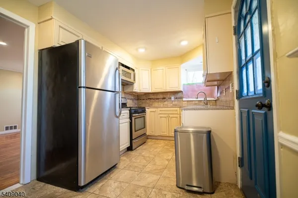 a kitchen with a refrigerator sink and cabinets