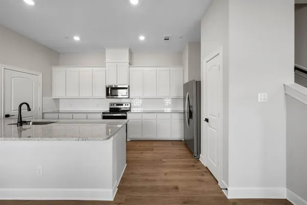 a kitchen with stainless steel appliances granite countertop a refrigerator and a sink