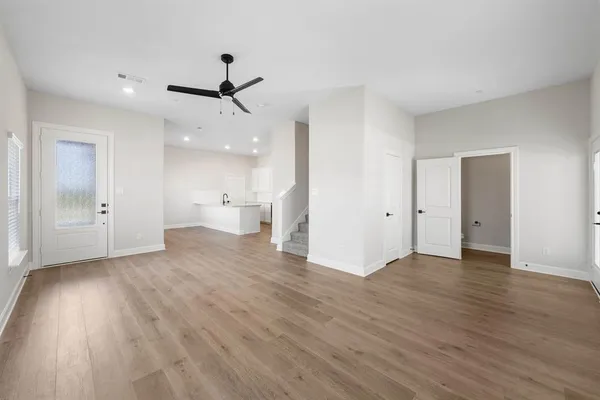 an empty room with wooden floor and windows