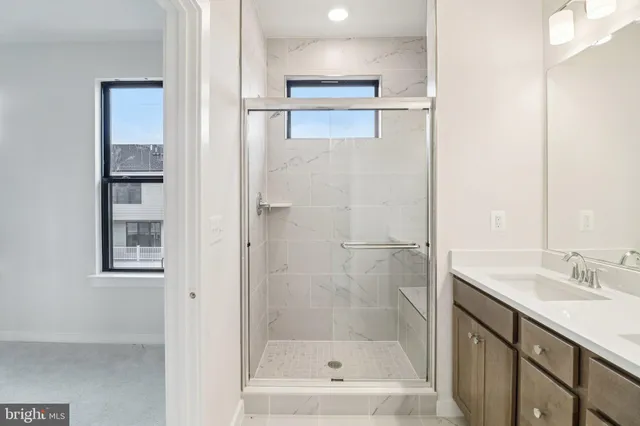 a bathroom with a shower sink and mirror