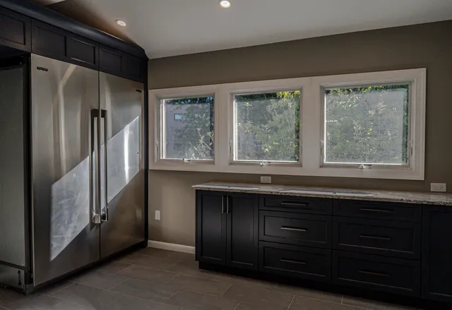 a kitchen with windows and refrigerator