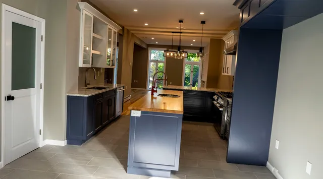 a kitchen with stainless steel appliances kitchen island granite countertop a refrigerator and a sink
