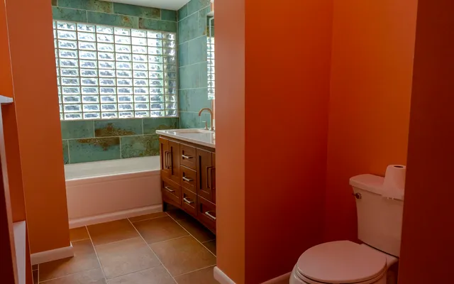 a bathroom with a granite countertop sink a mirror and a bathtub