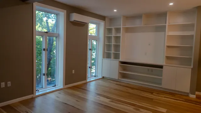 an empty room with wooden floor and closet