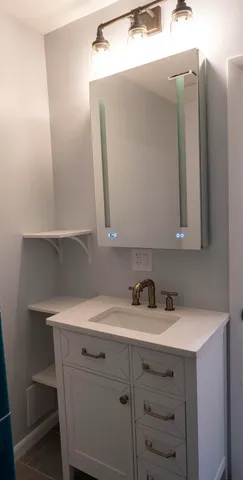 a bathroom with a sink vanity and mirror