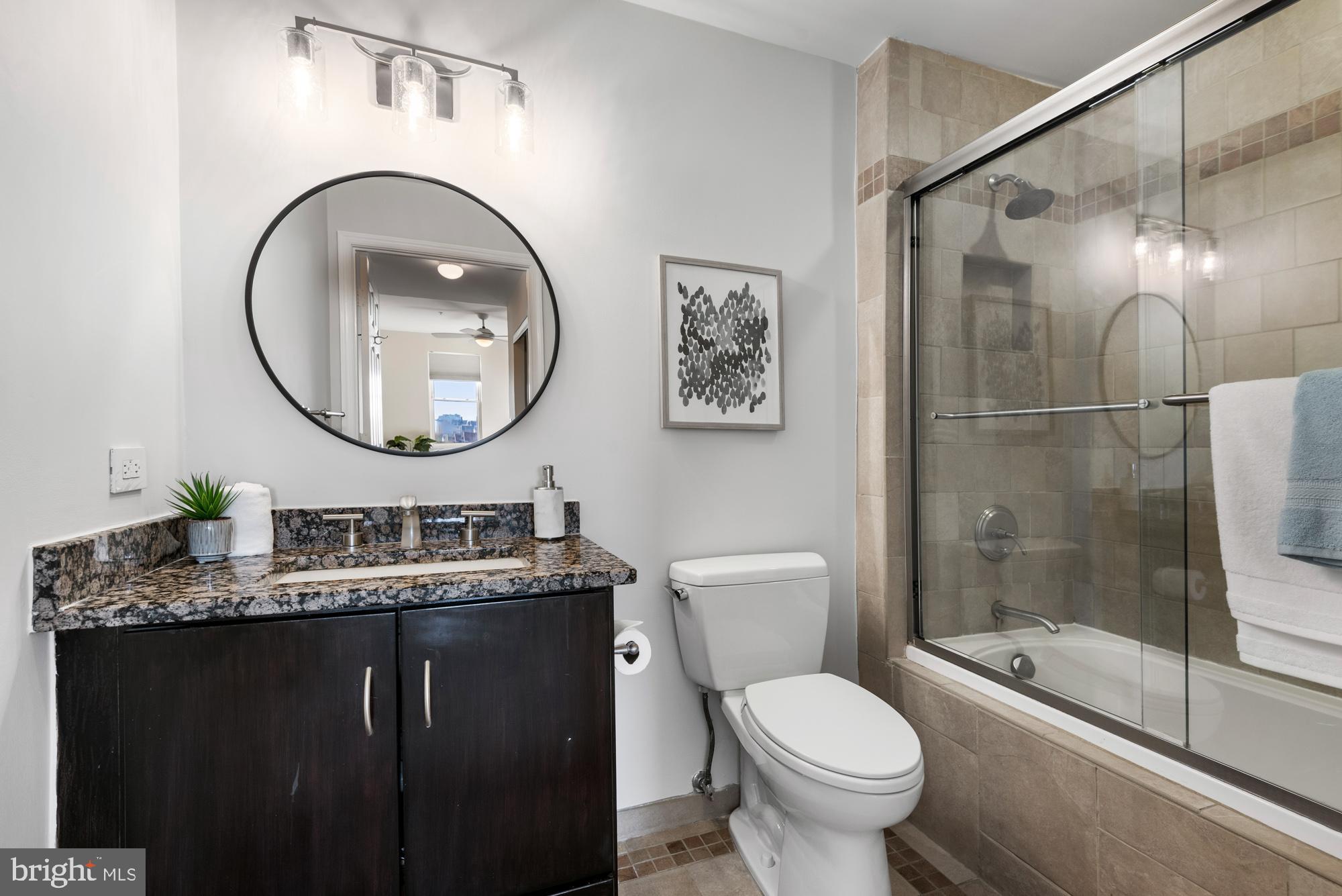 2001 12th Street Northwest, Unit 306 Washington, DC 20009 - Photo 20 of 36 a bathroom with a toilet sink vanity granite and a mirror