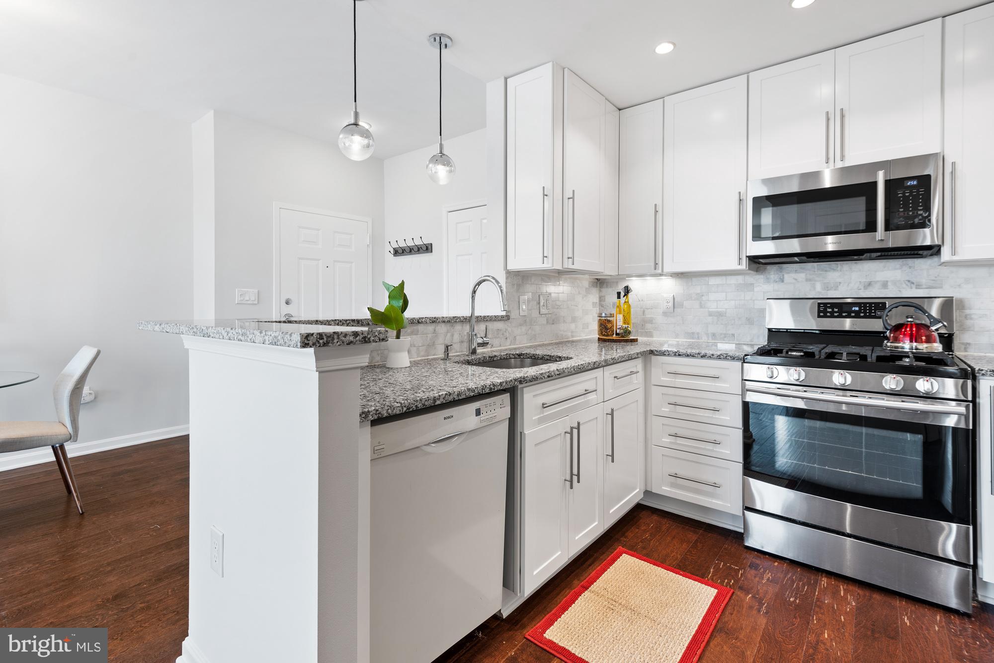 2001 12th Street Northwest, Unit 306 Washington, DC 20009 - Photo 10 of 36 a kitchen with stainless steel appliances granite countertop a stove a sink and a microwave