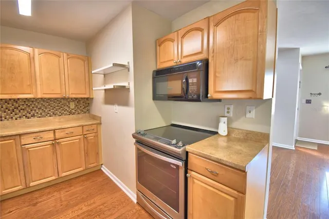 a kitchen with granite countertop cabinets stainless steel appliances a sink and wooden floor