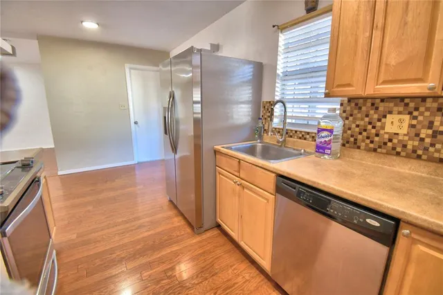 a kitchen with stainless steel appliances granite countertop a refrigerator and a sink