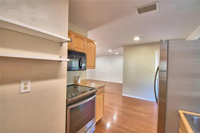 a kitchen with stainless steel appliances granite countertop a refrigerator a sink and a stove