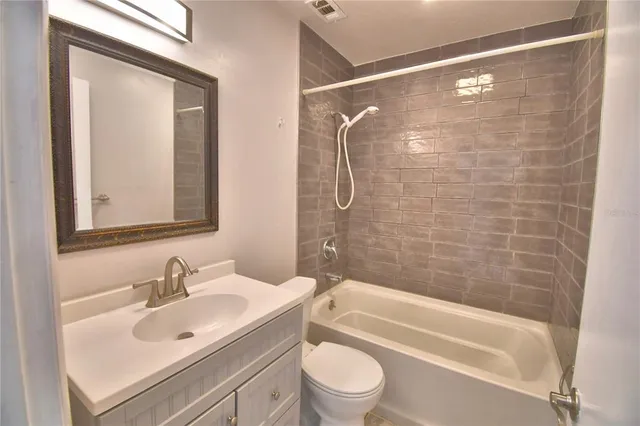 a bathroom with a bathtub shower sink vanity and toilet
