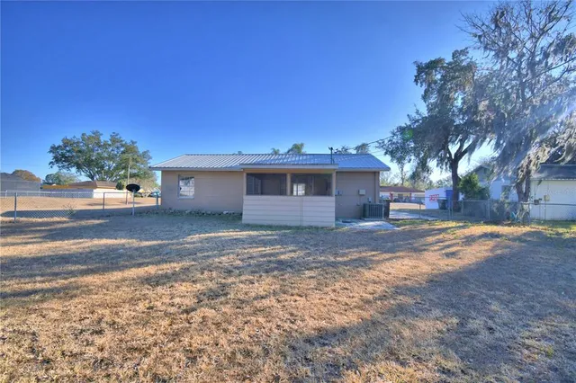 a view of a house with a yard and large tree