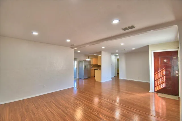 a view of an empty room with wooden floor