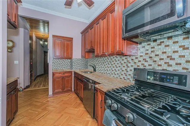 a kitchen with granite countertop a stove sink and cabinets