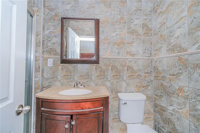 a bathroom with a toilet a sink and mirror