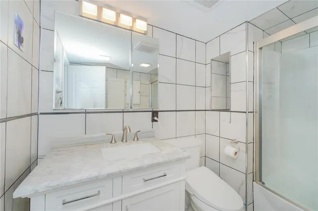 a bathroom with a sink toilet vanity and shower