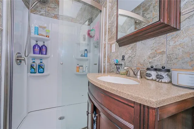 a bathroom with a granite countertop sink and a white cabinet