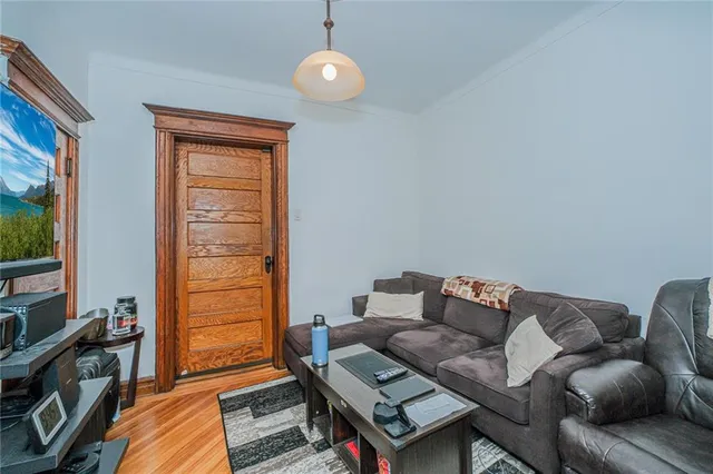 a living room with furniture a flat screen tv and a window