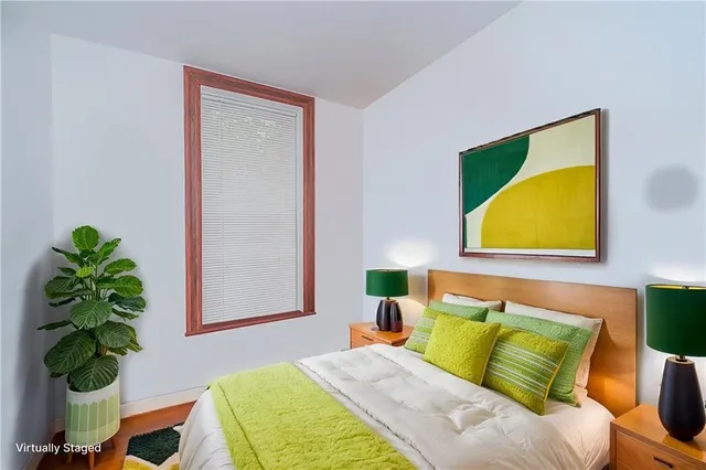 a bedroom with a bed and a painting on the wall