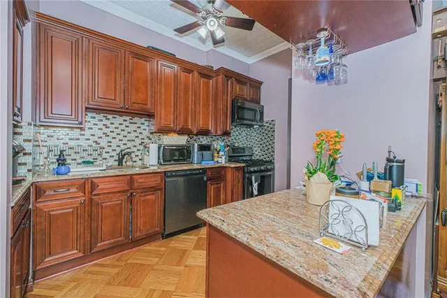 a kitchen with stainless steel appliances granite countertop a sink dishwasher a stove a dining table and chairs with wooden floor