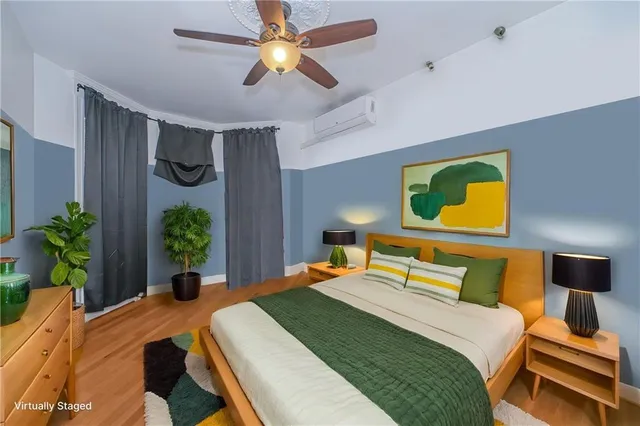 a bedroom with a bed a potted plant and a dresser