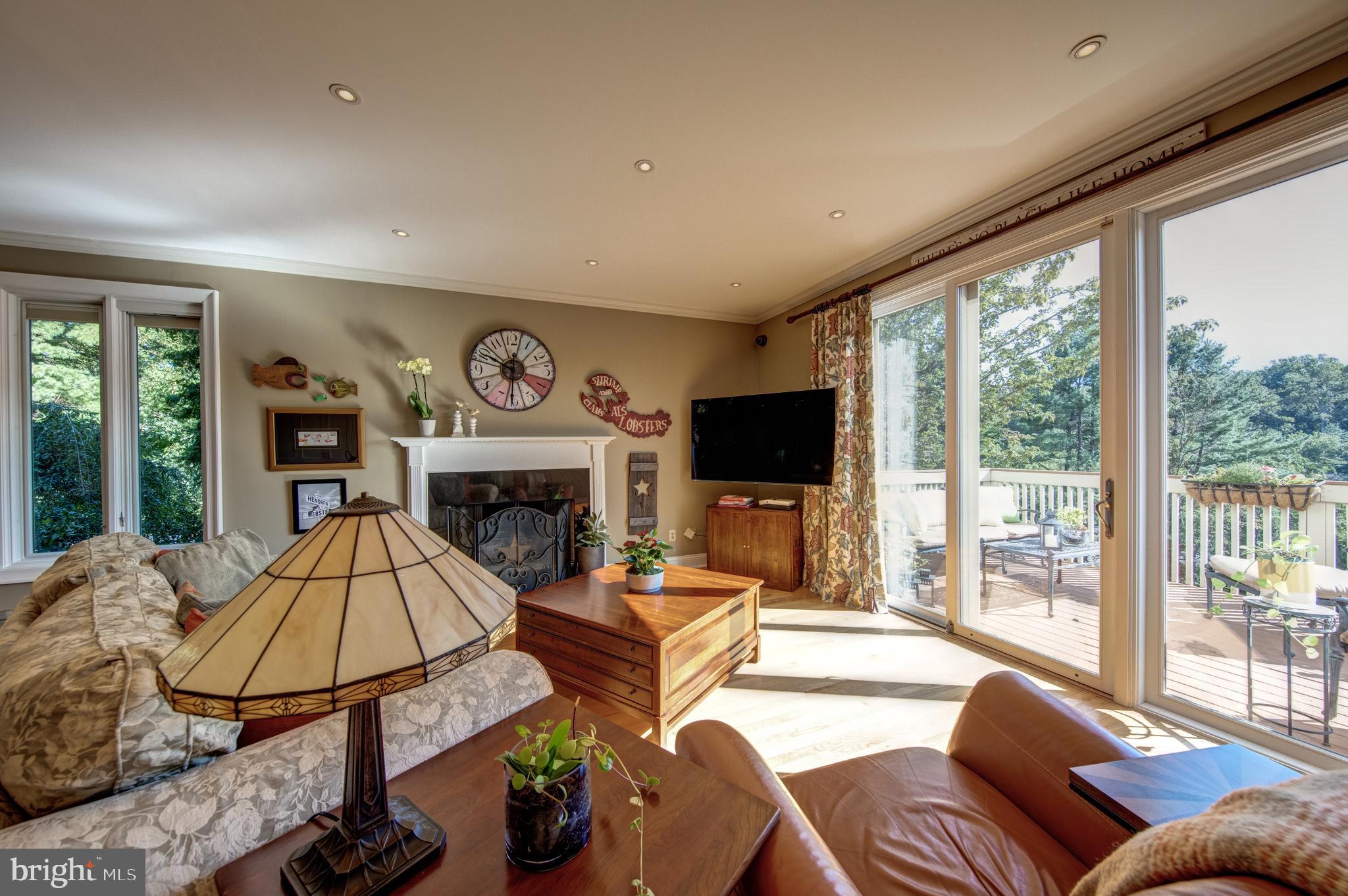 242 Ravenscliff Road Wayne, PA 19087 - Photo 12 of 49 a living room with furniture a fireplace and a floor to ceiling window