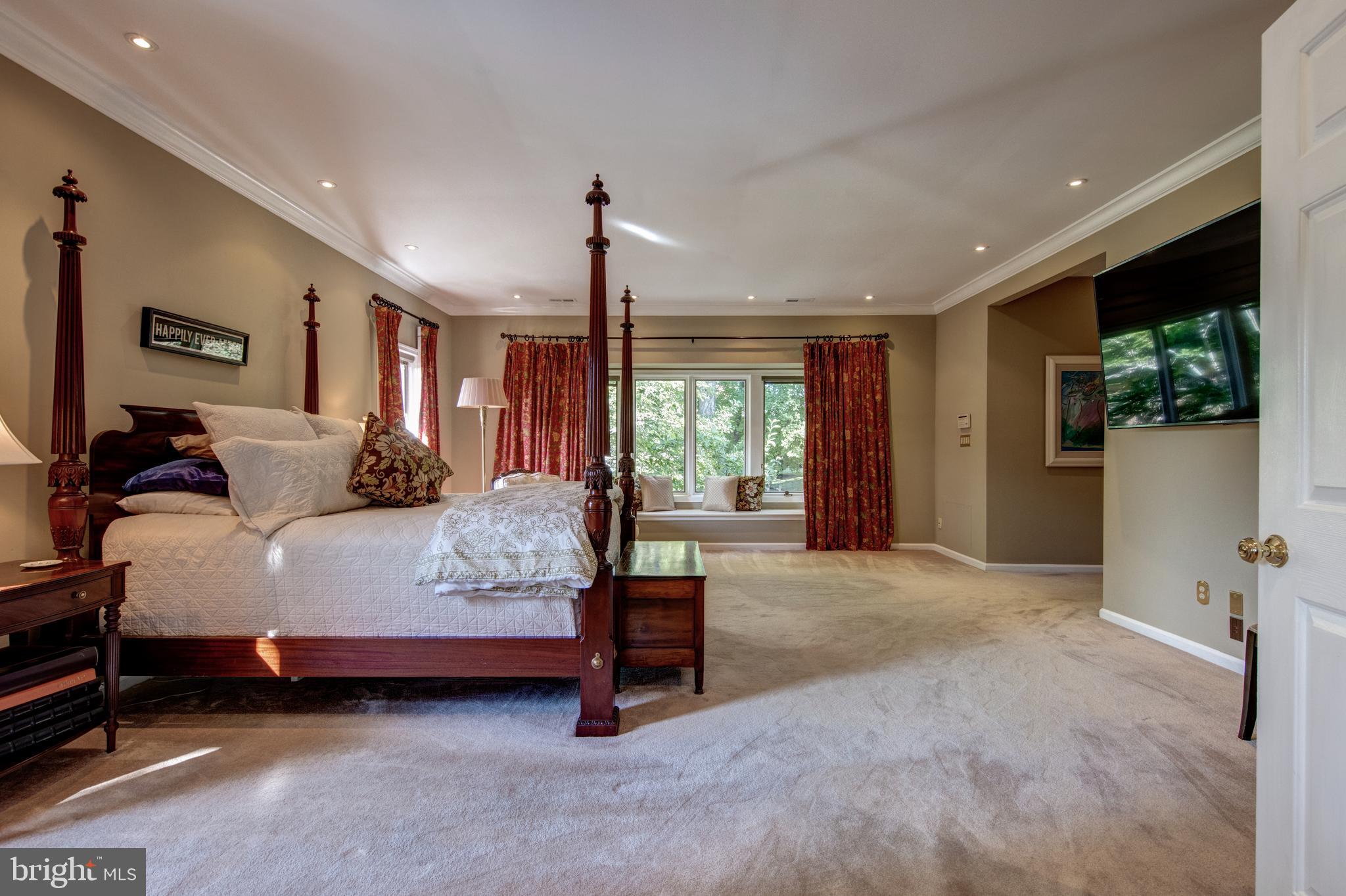 242 Ravenscliff Road Wayne, PA 19087 - Photo 20 of 49 a spacious bedroom with a bed a window and potted plant on the dresser