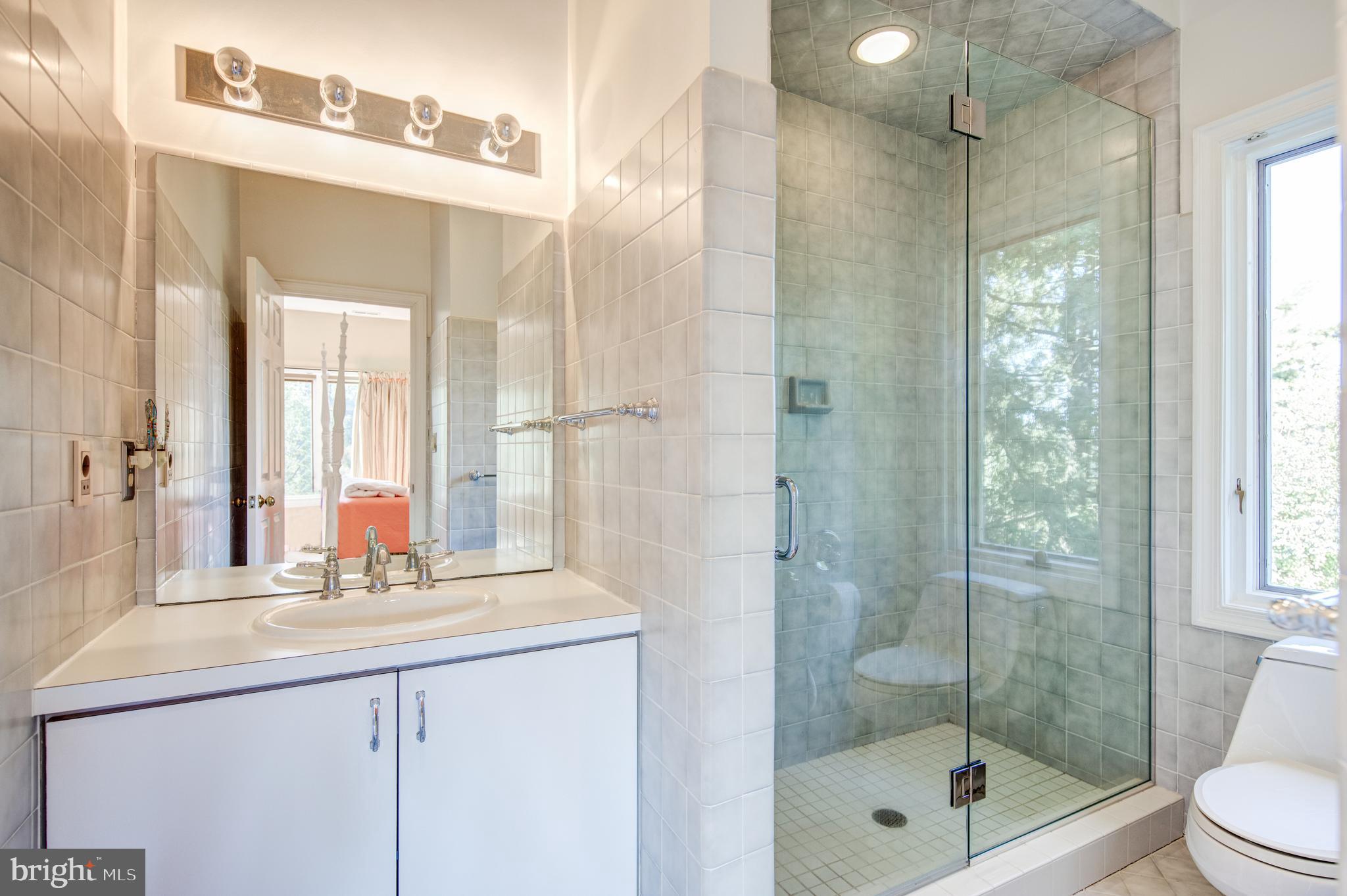 242 Ravenscliff Road Wayne, PA 19087 - Photo 28 of 49 a bathroom with a shower sink and mirror